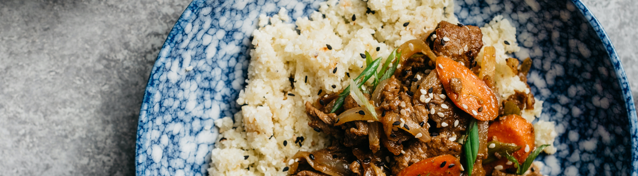 Beef and vegetables with rice in a blue bowl 