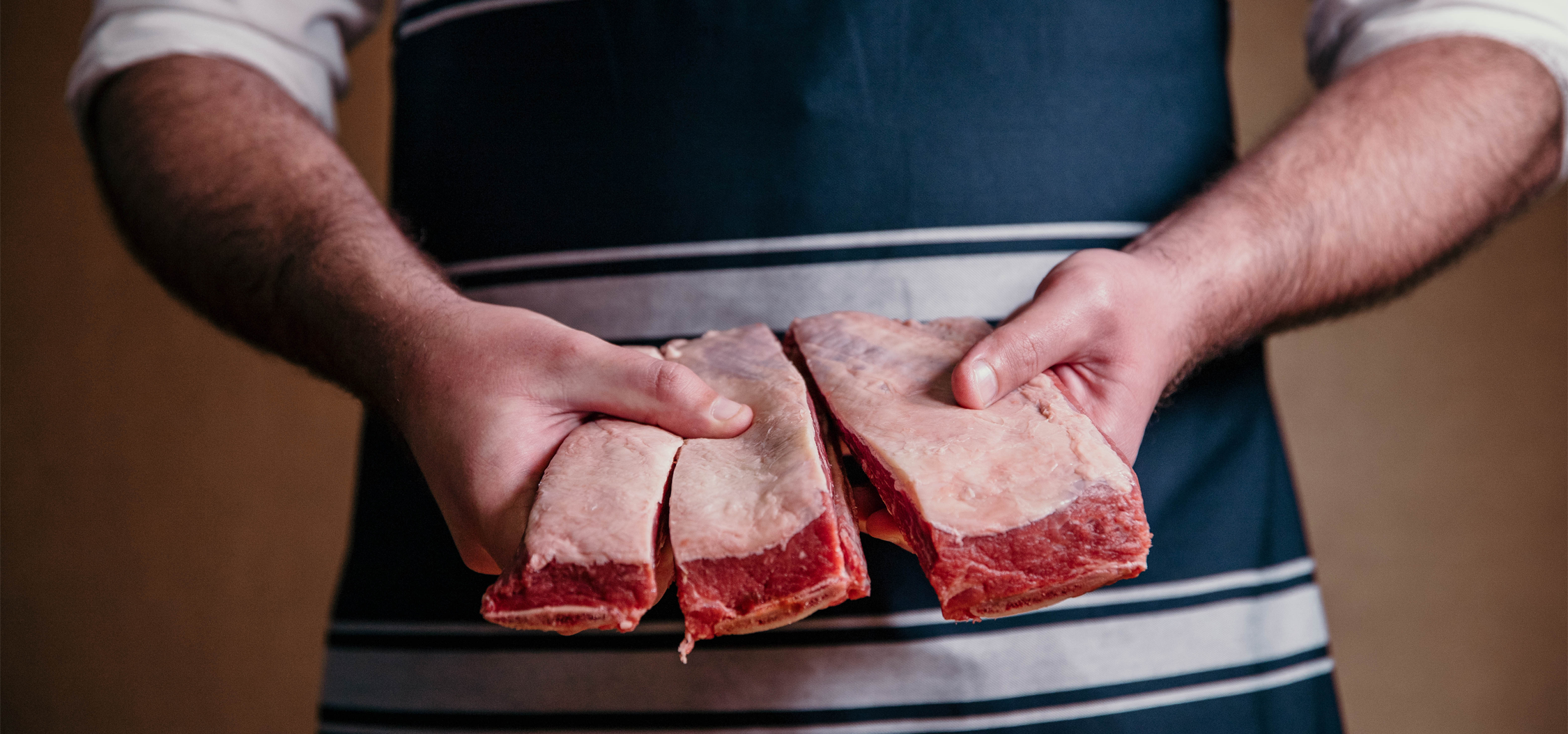 Man in an apron holding meat