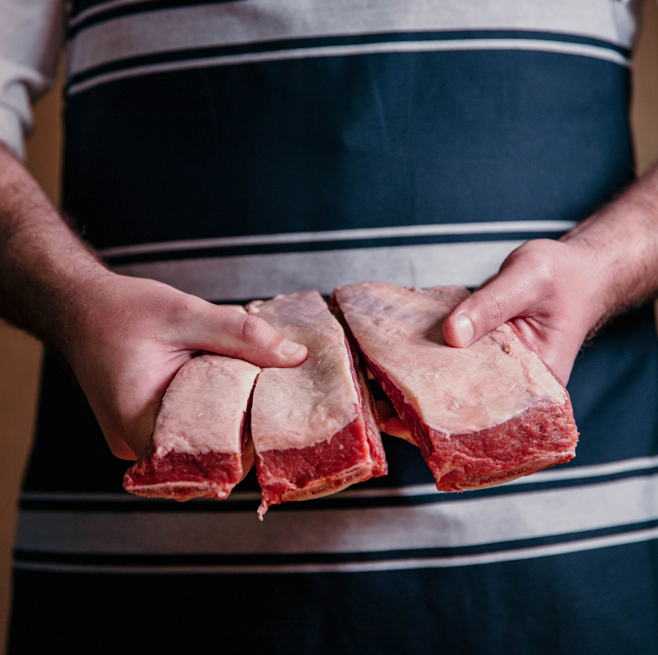 Man in an apron holding meat